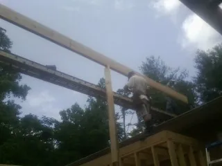 Carpenter setting a ridge beam over a new addition frame — Ice Dam Removal by Roofing Brothers in Walthourville