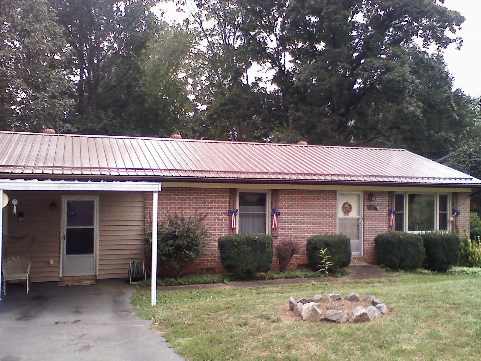 Bronze metal roof and carport on a brick ranch home — Roof Repair work by our crew in Walthourville